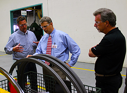 Todd Bramer, plant manager; US Representative Bill Huizenga; and Kaydon Bearings division president Jeff Manzagol view in-process custom bearings.
